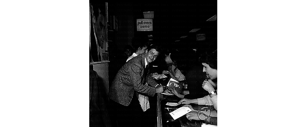 Sergio Endrigo circondanto di fans firma autogafi ad un bancone dei magazzini CIM - piano americano