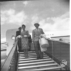 L'attore Bing Crosby con la moglie mentre scende dalle scalette dell'aereo. Campo medio