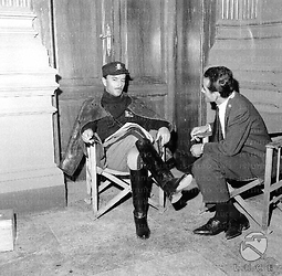 Giorgio De Lullo, nella parte di Pavolini, in divisa fascista, seduto, parla con un uomo