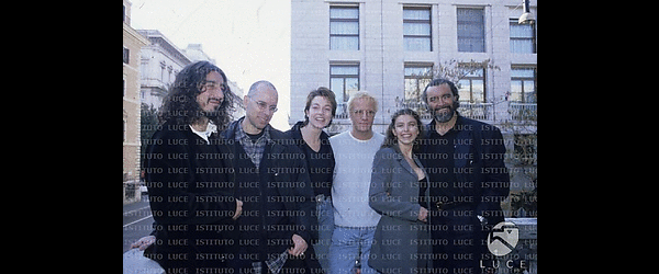 Il cast del film Nirvana: Sergio Rubini, il regista Gabriele Salvatores, Stefania Rocca, Christopher Lambert, Emanuelle Seigner, Diego Abatantuono. Sullo sfondo un palazzo.