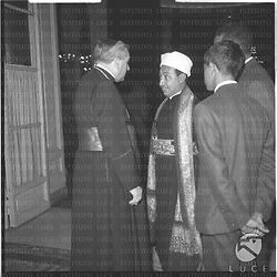Monsignor Carlo Grano e Mohammed Abdul Goddus al-Wazir (?) conversano in una sala del Grand Hotel in occasione di un ricevimento. Controcampo, piano americano