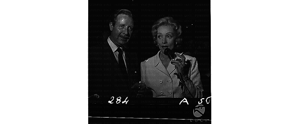 Marlene Dietrich ripresa con una rosa in mano ed una sigaretta accanto ad O'Connell - piano medio