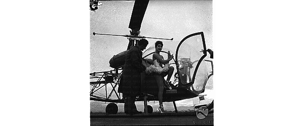 Vera Tschechowa ripresa mentre sale in un elicottero, un uomo in piedi le è accanto - totale