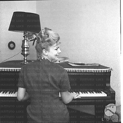 Ripresa di spalle Ketty Della Porta seduta davanti al pianoforte. Piano americano