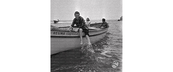 Ischia Valentina Cortese seduta sul bordo della barca con i piedi in acqua