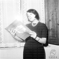 Franca Tamantini, nel suo appartamento, legge la partitura de La sonnambula. Una finestra dietro di lei; piano americano