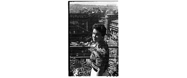 Miss O'Neil, giovane americana, ripresa su una terrazza di Roma centro dalla quale si scorge un'ampia area sottostante (forse piazza Barberini) - totale