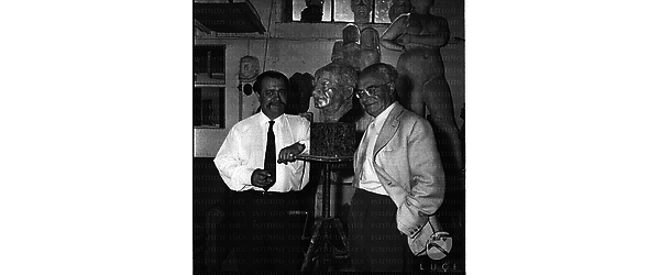 Lo scultore Peikov sorridente a sinistra ripreso con al centro un busto e forse con lo scrittore Vittorio Rossi - piano americano