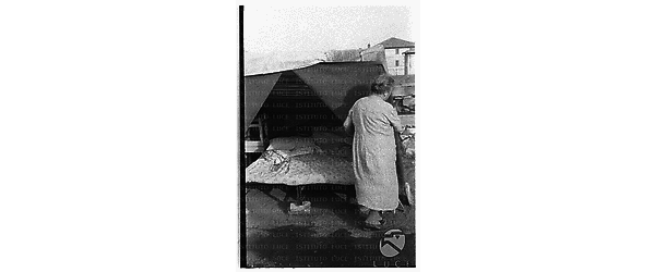 Una donna sistema il letto messo in una tenda costruita per le scosse di terremoto nella periferia di Terni - totale