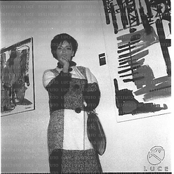 L'attrice Barbara Steele posa accanto ad un quadro esposto ad una mostra di pittura - piano americano