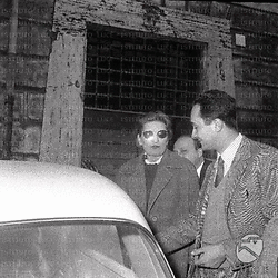 Edda Ciano Mussolini, accanto ad un accompagnatore nell'atto di aprirle lo sportello di un'automobile