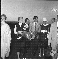 Dean Martin a Ciampino insieme ad una donna bionda, forse la moglie, l'attrice Eva Bartok e altre persone - totale