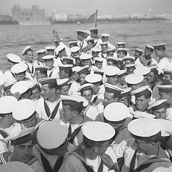 Un folto gruppo di marinai a bordo di una scialuppa della Vittorio Veneto che si dirige verso Taranto