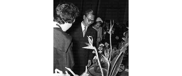 Un uomo giapponese e altre persone davanti alle sculture floreali giapponesi esposte in mostra - piano americano