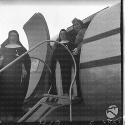 Due suore decorate, tra cui suor Maria Letizia, colte sulla scaletta di un aereo della LAI in partenza per Cagliari. Totale