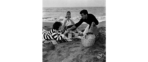 Lynn Shaw con Alessandra Panaro e Fulvio Carrara seduti sulla spiaggia di Ostia. Piano medio