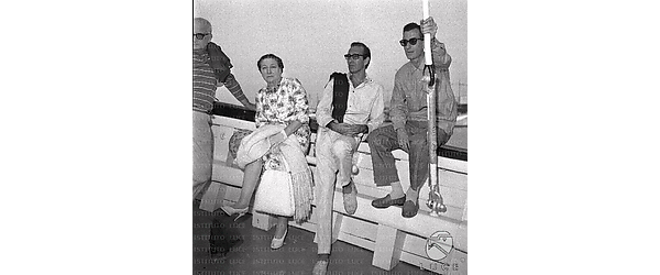 La Borboni seduta sulla parete esterna di una nave insieme ad alcuni uomini della troupe, tra cui il regista Lizzani