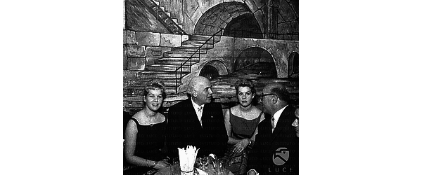 Gino Bechi al ristorante in compagnia di due donne, probabilmente gemelle, e di altre persone