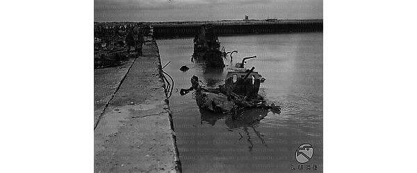 La delegazione di autorità civili e militari italo-tedesche sul molo del porto di Dunkerque di fronte ai relitti di alcune navi alleati distrutte dai bombardamenti della Luftwaffe