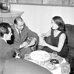 Franca Tamantini e due uomini, seduti intorno a un tavolino, conversano tra loro