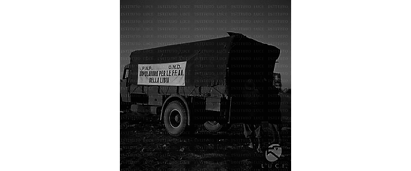 mediterraneo Soldati scaricano del materiale da un camion con le insegne dell'O.N.D. e del P.N.F.