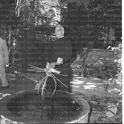 Don Giovanni Rossi in un giardino vicino ad una fontana - campo medio