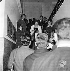 Gina Lollobrigida scende le scale circondata da giornalisti e fotografi