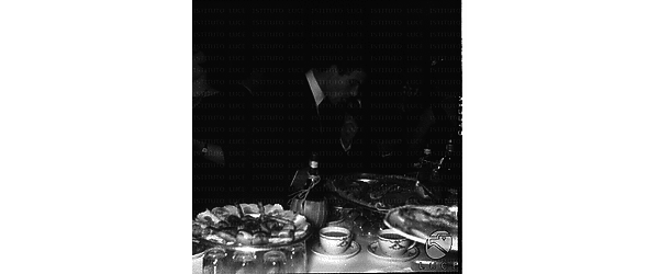 Uno degli ospiti (forse Nino Castelnuovo) ripreso durante il cocktail per il film 'Fuga a Firenze' al tavolo del buffet - piano americano