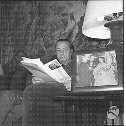 Sandro Pallavicini seduta su una poltrona con in mano una rivista. Piano americano