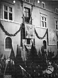 Roma Inquadratura del balcone di Palazzo Venezia dal basso; Hitler, Hess, Mussolini e Ribbentrop sono affacciati ed osservano la folla sottostante