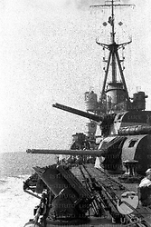 Marinai, cannoni e torre superiore di una grande nave da guerra italiana in navigazione