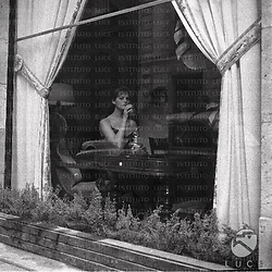 Parigi Claudia Cardinale beve qualcosa dietro la vetrata di una hall