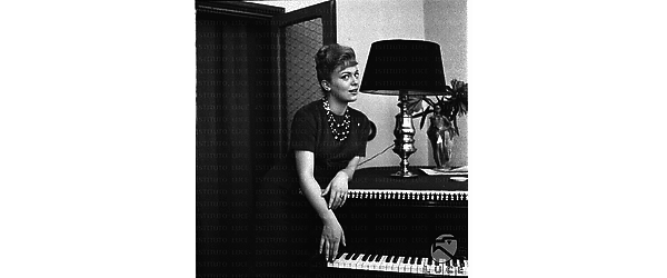 Ketty Della Porta in posa vicino ad un pianoforte. Piano americano