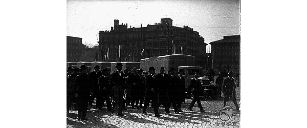 Roma Su piazza Venezia, Mussolini e le altre autorità presenti marciano a fianco dell'autotreno del grano durante i primi metri del viaggio inaugurale