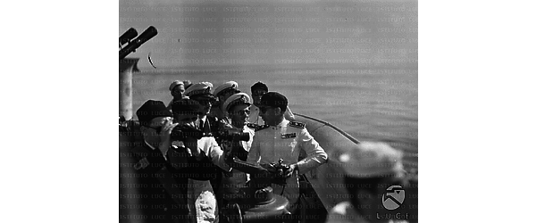 Marinai, ufficiali e graduati scrutano l'orizzonte da una torretta su una nave da guerra italiana in navigazione