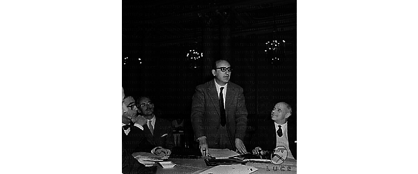 Sindacalista tiene discorso al tavolo degli oratori durante un convegno della C.G.I.L; accanto a lui Santi ed altre personalità - piano americano