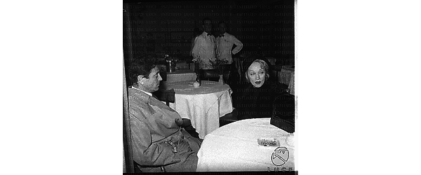 Piano medio di Marlene Dietrich e Raf Vallone seduti ad un tavolino