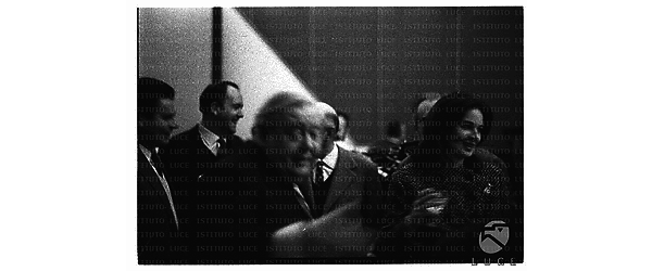 In primo piano (sfocato)  Charles Laughton dietro Eleonora Rossi Drago e altre persone durante il cocktail  del film Sotto dieci bandiere - piano medio