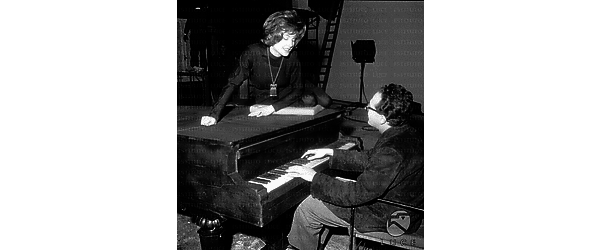 Gabriella Farinon seduta sopra il pianoforte mentre Vulpiani lo suona