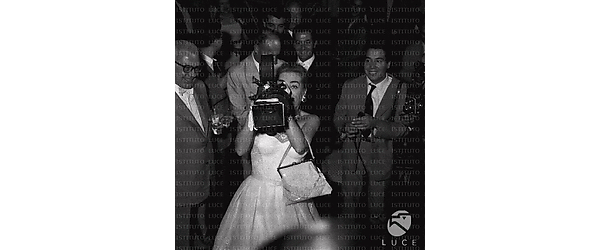 Roma Joan Crawford con la telecamara (macchina da presa) rivolta verso l'obiettivo; il marito sorride