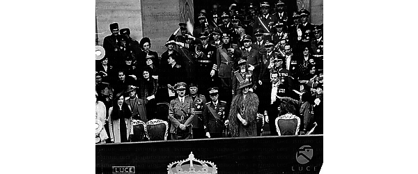 Roma Inquadratura della tribuna d'onore; Mussolini, Hitler che saluta con il braccio teso; Ribbentrop, Goebbels che sorride, il Re che fa il saluto militare, la Regina, Hess, Badoglio che ride, De Bono e sullo sfondo Anfuso e Alfieri