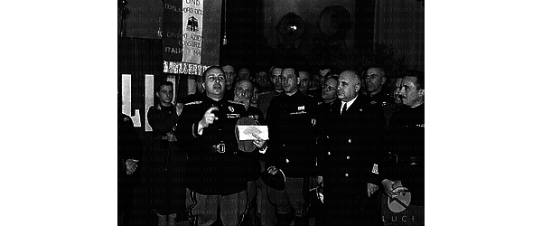 Roma Adelchi Serena tiene un discorso, alla presenza di numerosi federali, accanto a lui, davanti a un giovane milite che esibisce uno stendardo dell'Opera nazionale dopolavoro del gruppo aziendale del C.I.M.