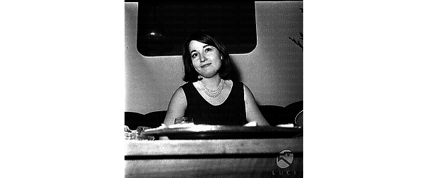 Franca Tamantini seduta su un divano durante la riunione. Il piano di un tavolino in primo piano