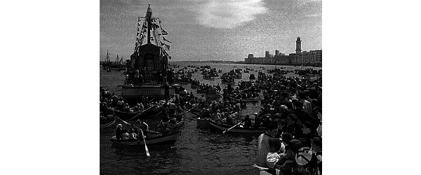 Bari La caravella su cui è portata in processione al largo la statua del santo patrono è circondata da decine di piccole imbarcazioni cariche di fedeli; altri devoti seguono la manifestazione affollandosi sul molo San Nicola