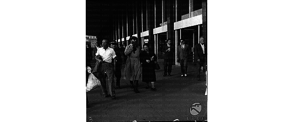 Curiosi personaggi attraversano la hall della stazione Termini. Campo medio