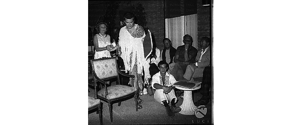 Roloff Beny, in costume di tipo africano, insieme ai suoi ospiti durante il ricevimento in casa sua - totale