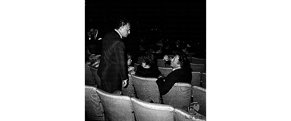 Fellini conversa con Rod Steiger in piedi dietro di lui