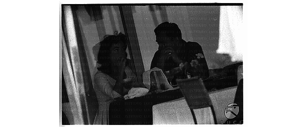 Michael Todd ed Elizabeth Taylor seduti in un bar - piano americano