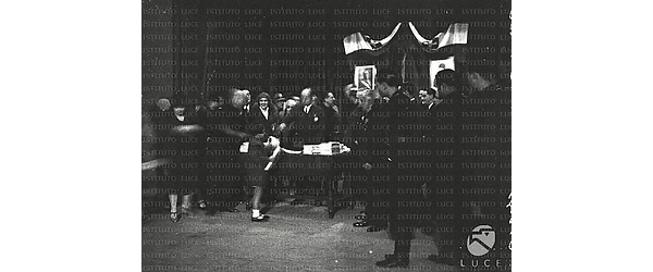 Roma Mussolini consegna i doni ai bambini sul palco di un teatro di Testaccio