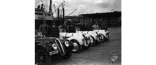 Napoli Alcuni piloti posano accanto alle loro auto da corsa, disposte in fila lungo una banchina del porto di Napoli per essere imbarcate